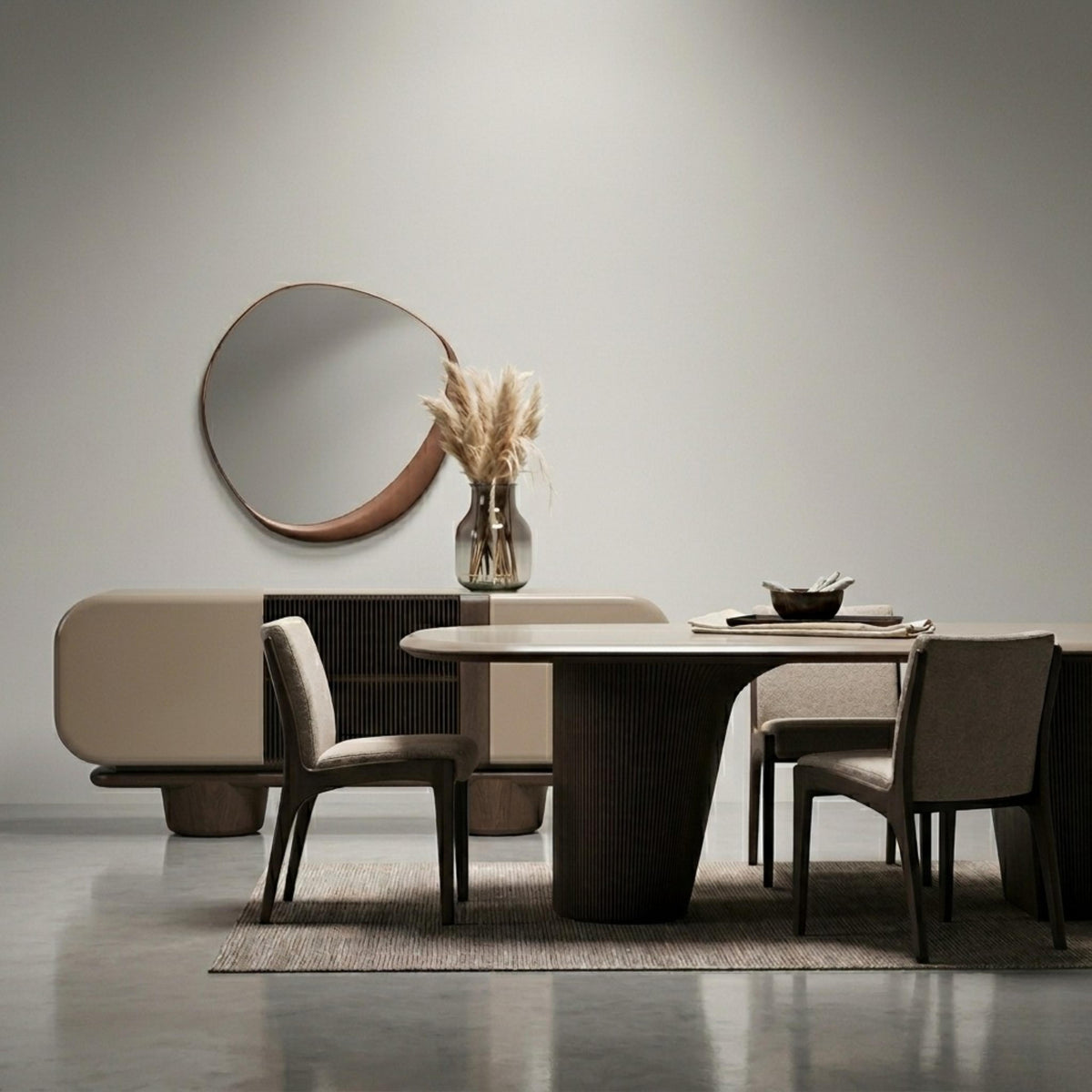 Modern dining room set with rounded table, upholstered chairs, wood-detailed sideboard, and an organic wall mirror.