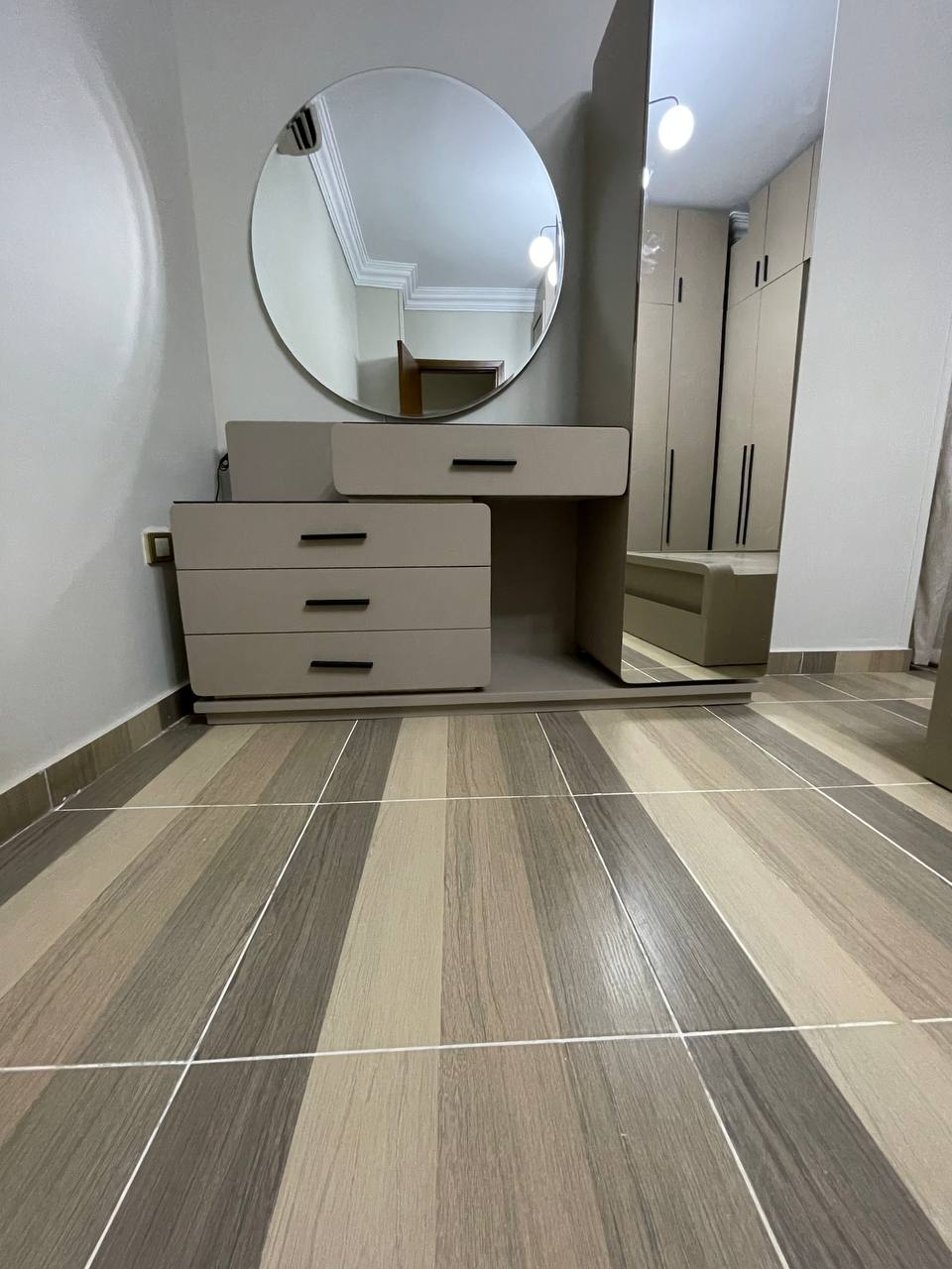 تسريحة غرفة نوم مودرن بمرآة دائرية مضيئة LED وتصميم طافٍ موفر للمساحة