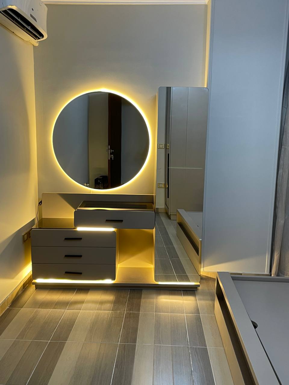 تسريحة غرفة نوم مودرن بمرآة دائرية مضيئة LED وتصميم طافٍ موفر للمساحة
