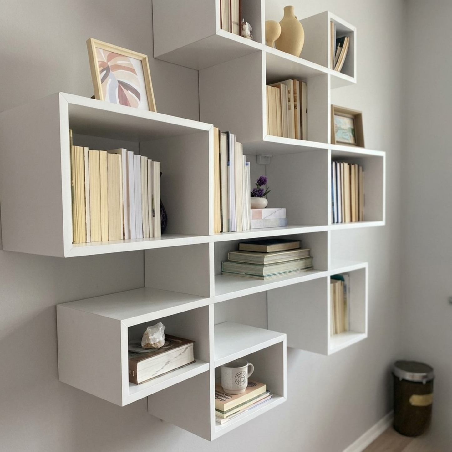 مكتبة حائط معلقة مودرن - أرفف خشبية بيضاء بتصميم هندسي متداخل