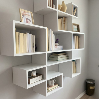 مكتبة حائط معلقة مودرن - أرفف خشبية بيضاء بتصميم هندسي متداخل
